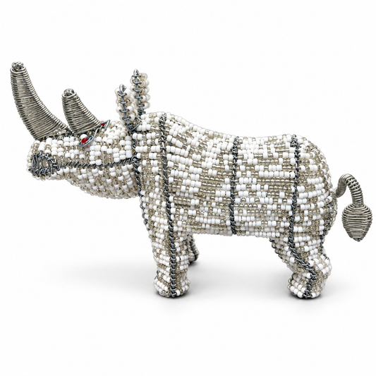 A rhinoceros figurine crafted from silver wire and white, silver, and gray beads, featuring small red eyes, shown against a plain white background.