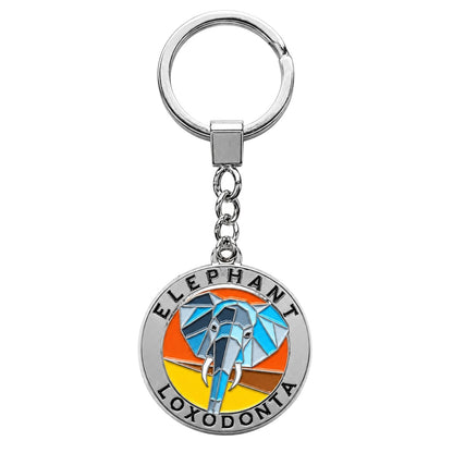 A silver metal keychain featuring a circular charm with a colorful geometric elephant design and the text 'ELEPHANT LOXODONTA' on a plain white background.